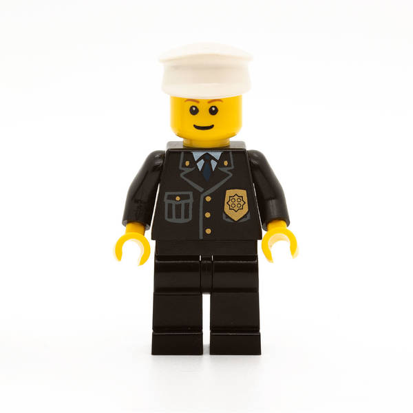 LEGO cty0005 -Police (City Suit with Blue Tie and Badge, Black Legs, White Hat, Brown Eyebrows, Thin Grin)